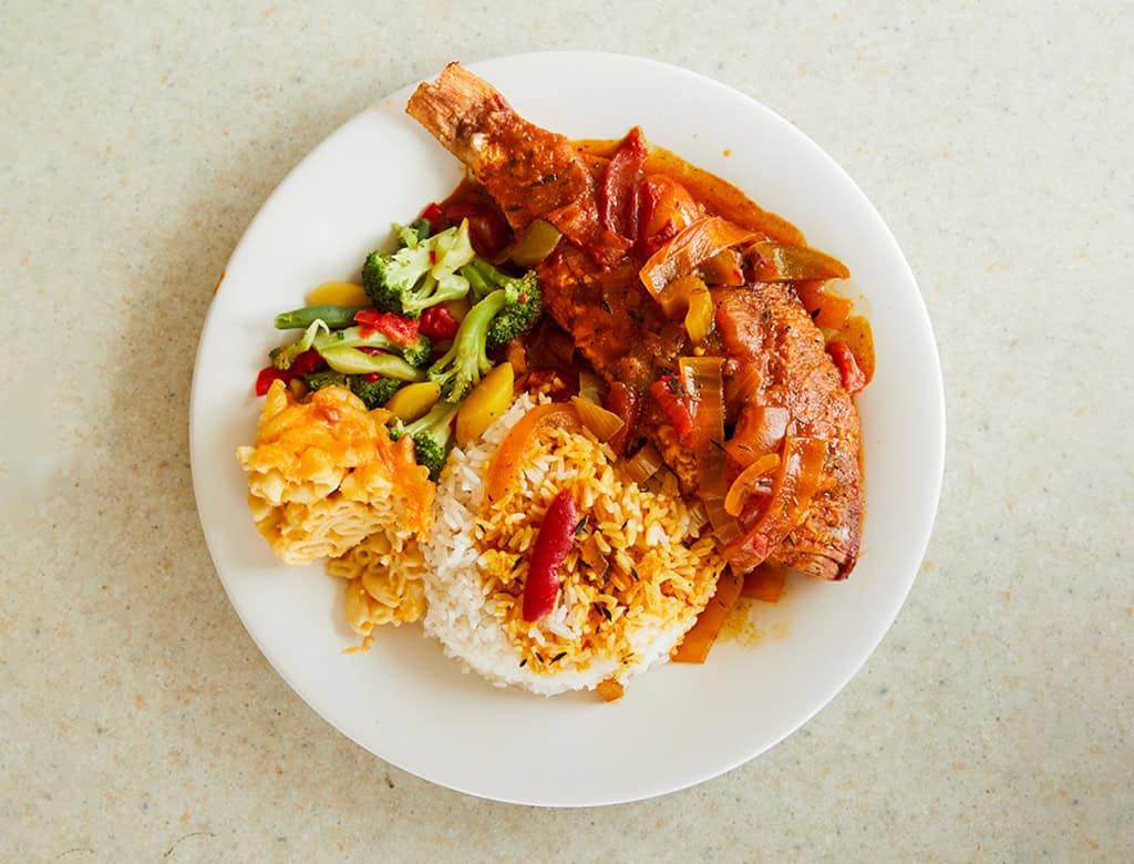 A plate is piled high with traditional USVI cuisine.