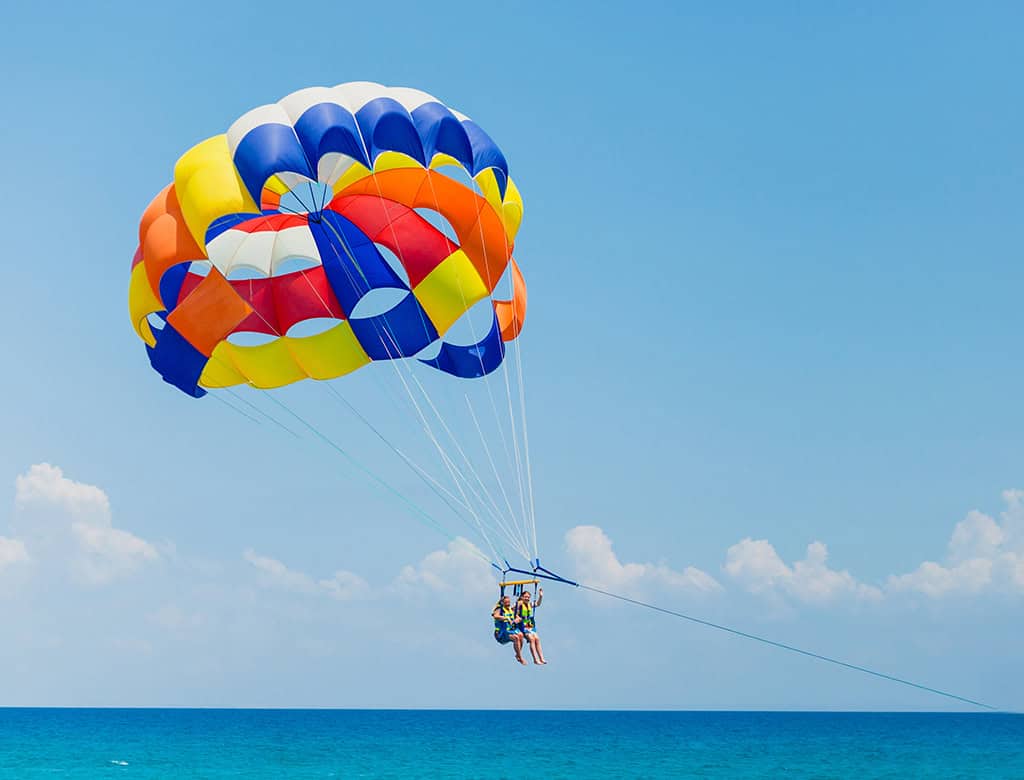 A person parasails through the sky above the water in the US Virgin Islands