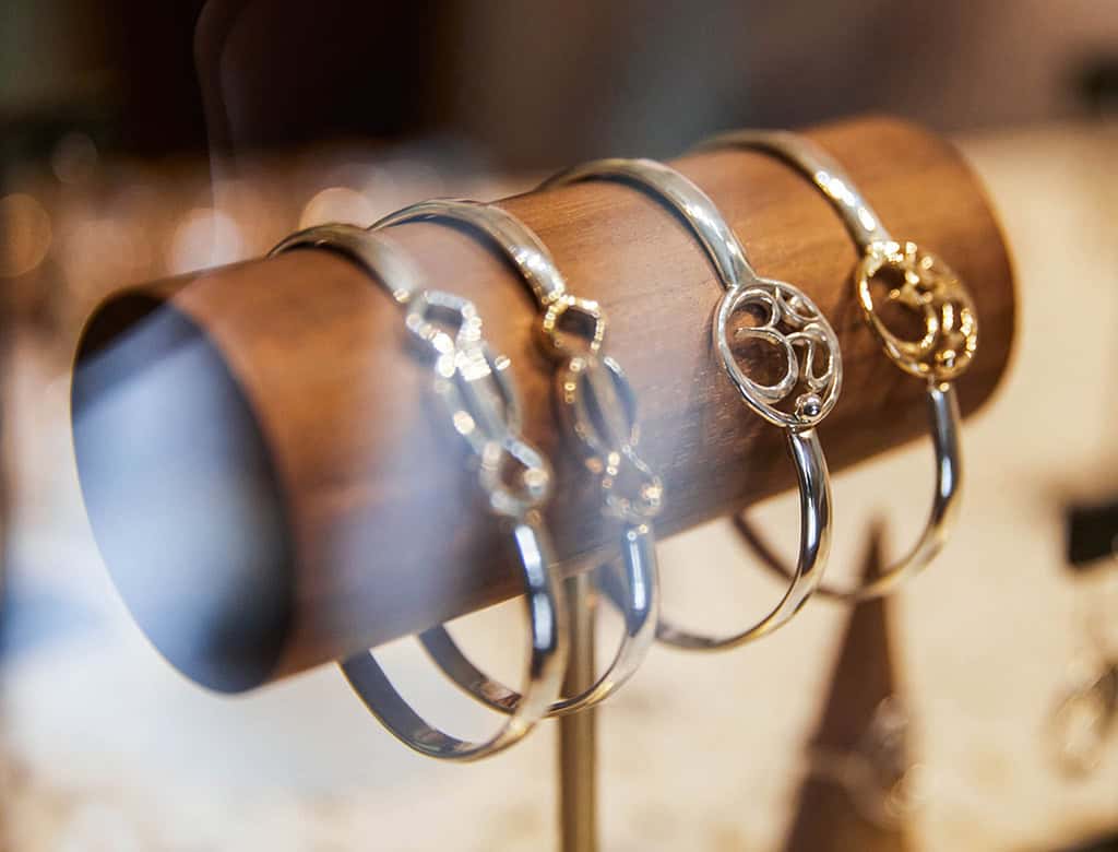 Crucian hook bracelets are set on a wood display at a jewelry store in USVI