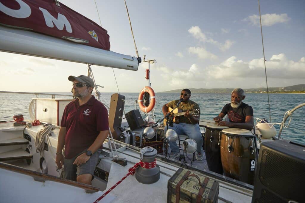A band plays a guitar and bongo drum aboard a boat tour off of St. Croix