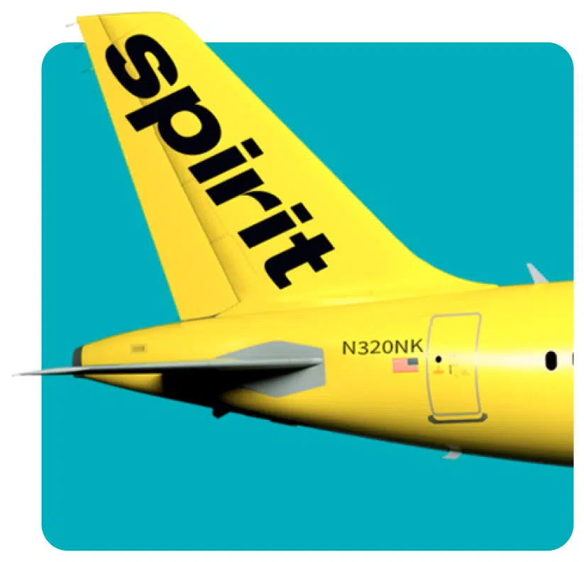 Yellow tail section of a Spirit Airlines airplane with the word "Spirit" in large black letters and registration number N320NK on a turquoise background.
