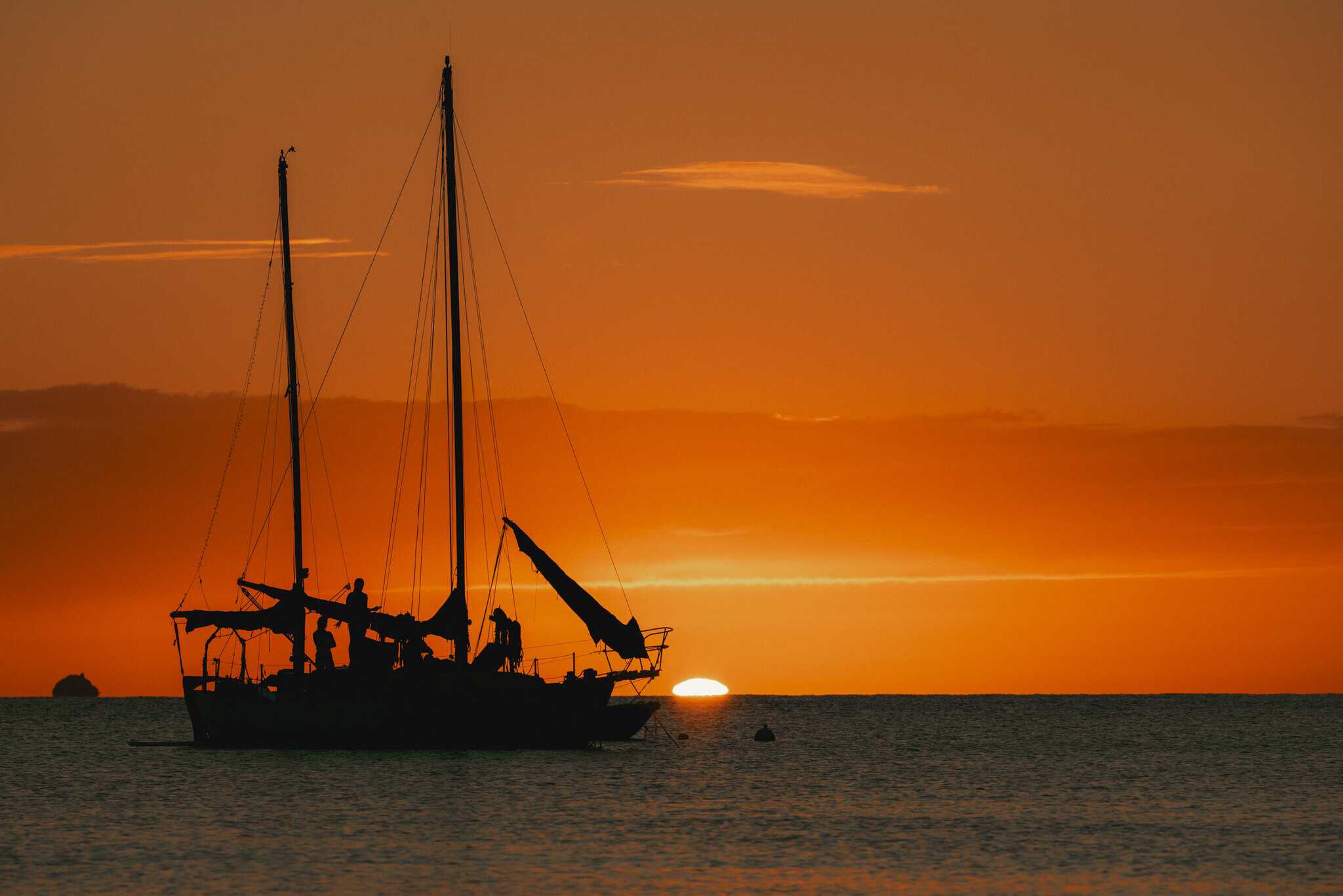 Silhouette of a sailboat on the water during a bright orange sunset in the waters off St. Croix.