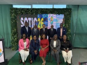 A group of ten people posed for a photo in front of a backdrop reading “SOTIC 26.”